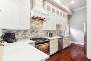 a kitchen with white cabinets and a stove top oven at Amazing 3bedroom townhome, in Historic Dryade City in New Orleans