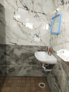 bagno con lavandino e specchio di Kamal nivas service apartments a Chikmagalūr