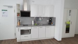 a white kitchen with white cabinets and a sink at Neckarzeit in Neckarwestheim