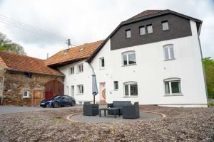 un edificio blanco con un coche aparcado delante de él en The Ring Inn, en Adenau