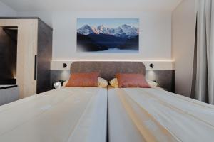 - une chambre avec un grand lit blanc et des montagnes dans l'établissement Hotel Central Wolter - Grindelwald, à Grindelwald