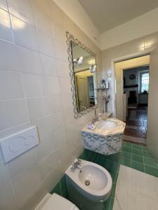 een badkamer met een wastafel, een toilet en een spiegel bij Villa Favilli in Pisa