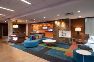 エドモントンにあるFairfield Inn & Suites by Marriott Edmonton Northのロビー(青いソファ、テーブル、椅子付)