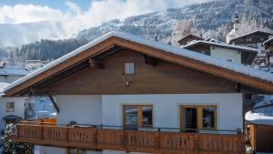 een huis met een met sneeuw bedekt dak en een balkon bij Appartement Anja in Fügen