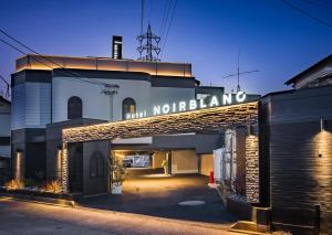 un bâtiment avec un panneau indiquant les miami nolens dans l'établissement Hotel Noir Blanc, à Shizuoka