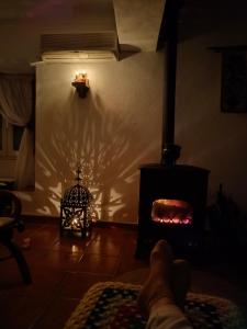 a persons feet in a living room with a fireplace at Casa da Muralha in Estremoz