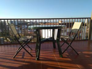 d'une table verte et de deux chaises sur le balcon. dans l'établissement Vistas encantadoras, à Matalascañas