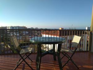 d'une table en verre et de deux chaises sur un balcon. dans l'établissement Vistas encantadoras, à Matalascañas