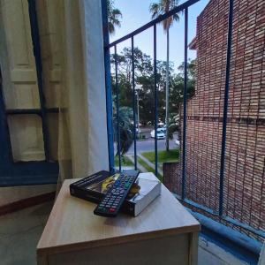 une télécommande assise sur une table à côté d'une fenêtre dans l'établissement Rambla Atlantida Villagio, à Atlántida