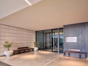 una hall con panche e piante in un edificio di Grand Hyatt Kuwait Residences a Kuwait