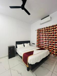 una camera con letto e ventilatore a soffitto di MATHER RAJAGIRI FURNISHED APARTMENTS ad Alwaye