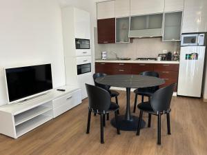 a kitchen with a table and chairs and a television at Valverde Apartment and Rooms in Verona