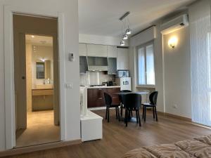 a living room and kitchen with a table and chairs at Valverde Apartment and Rooms in Verona