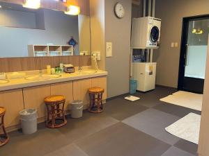 a bathroom with two sinks and two stools at Hotel Route-Inn Akita Tsuchizaki in Akita