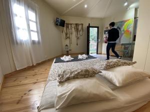 Ein Mann, der in einem Zimmer mit einem großen Bett geht in der Unterkunft YMCA Camp Alambre in Azeitão