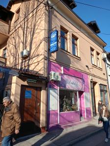 a man walking down a street in front of a building at Apartment and rooms"Tabašnice"Tuzla centar in Tuzla