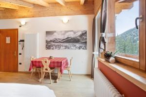 uma sala de jantar com uma mesa e uma janela em Chalet Primula 14 em Santa Caterina Valfurva