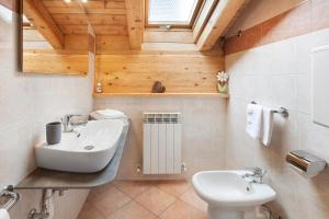 uma casa de banho com um lavatório e um WC em Chalet Primula 14 em Santa Caterina Valfurva