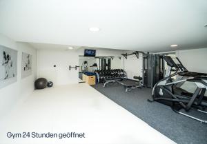 einen Fitnessraum mit zwei Laufbändern und zwei Maschinen in der Unterkunft Das Aunhamer Suite & Spa Hotel in Bad Griesbach