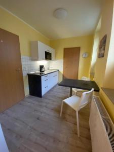 una pequeña cocina con mesa y silla blanca en Apartments in der Rostocker Innenstadt, en Rostock