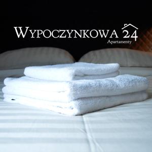 un mucchio di asciugamani bianchi seduti su un letto di Apartamenty Wypoczynkowa 24 - 700m od Park Wodny Suntago Wręcza a Krzyżówka