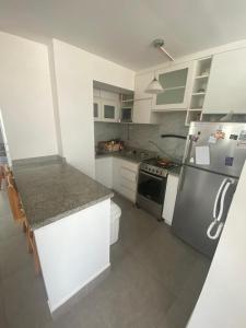 a kitchen with a refrigerator and a counter top at Playa Norte Experience in Punta Hermosa