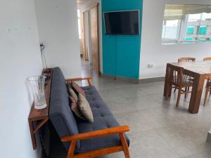 a living room with a blue couch and a table at Playa Norte Experience in Punta Hermosa