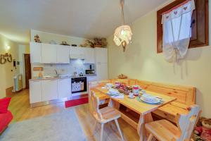 a kitchen with a wooden table and chairs in a room at Studio Grange Nest Ski & Relax - Happy Rentals in Sestriere