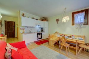 a living room with a table and a kitchen at Studio Grange Nest Ski & Relax - Happy Rentals in Sestriere