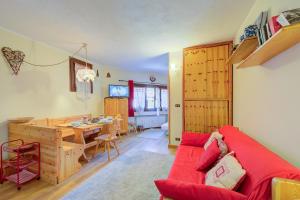 a living room with a red couch and a table at Studio Grange Nest Ski & Relax - Happy Rentals in Sestriere