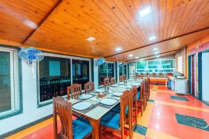 un comedor con una mesa larga y sillas en Treebo Raval Resort with Valley View, en Panchgani