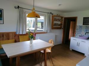 une cuisine avec une table et un vase de fleurs. dans l'établissement Ferienhaus Asterbach, à Gosau