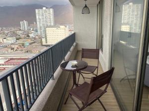 einen Balkon mit zwei Stühlen und einem Tisch darauf in der Unterkunft Surf and Relax Apartment in Iquique