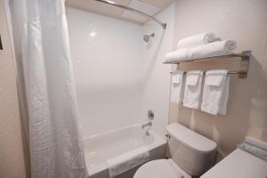 y baño blanco con aseo y ducha. en Holiday Inn Cleveland-Mayfield, an IHG Hotel, en Mayfield