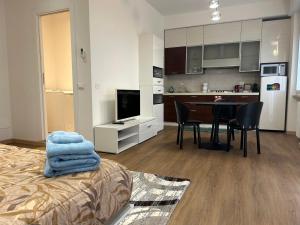 a room with a bed and a kitchen with a table at Valverde Apartment and Rooms in Verona