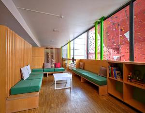 una sala de espera con sofás verdes y una mesa en Youth Hostel Echternach, en Echternach