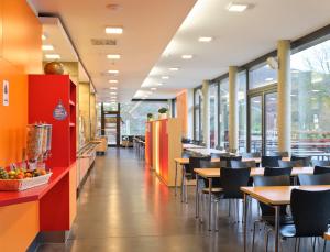 una zona de comedor con mesas y sillas en un restaurante en Youth Hostel Echternach, en Echternach