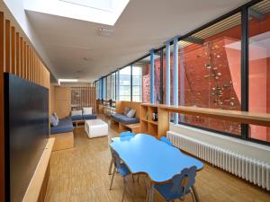 Habitación con pared de escalada, mesa y sillas en Youth Hostel Echternach, en Echternach