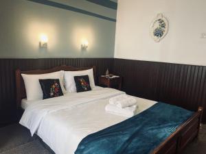 a bedroom with a large bed with towels on it at Pilioritiko Spiti in Makrinítsa