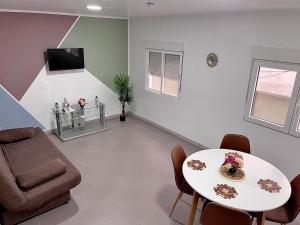 a living room with a table and a couch at BEL APPARTEMENT ROSES PLAGE in Roses