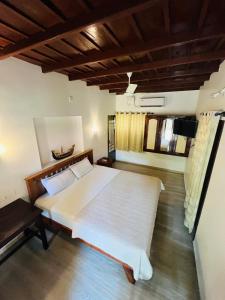 a bedroom with a large white bed in a room at Dove cottage in Cherai Beach