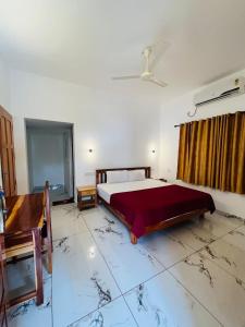 a large bedroom with a bed and a piano at Dove cottage in Cherai Beach