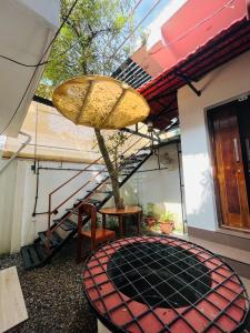 a patio with a table and a tree and stairs at Dove cottage in Cherai Beach