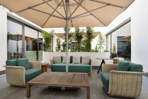 patio con sedie, tavolo e ombrellone di Hilton Porto Gaia a Vila Nova de Gaia