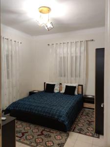 a bedroom with a bed with a blue comforter at Amalias - city oasis in Thessaloniki