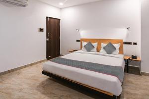 - une chambre avec un grand lit dans l'établissement Super Townhouse De Alphabet Karmanghat, à Hyderabad