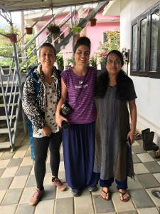 three women standing next to each other on a porch at SpiceGreen Homestay,Thekkady in Thekkady