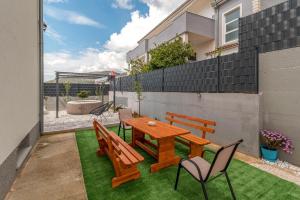 a patio with a wooden table and chairs at luxury apartment with garden jacuzzi in Trogir