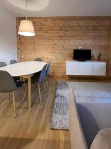 - une salle à manger avec une table, des chaises et une télévision dans l'établissement Condominio Le Grange - Casa E, à Sauze dʼOulx