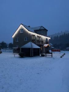 ein großes Haus mit Schnee seitlich in der Unterkunft Карпатські Зорі in Pilipets